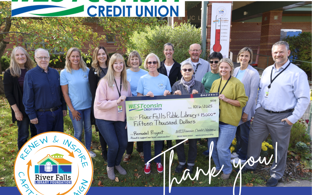 14 people holding a giant check for $15,000 standing in front of a the library building with brick and trees in the background