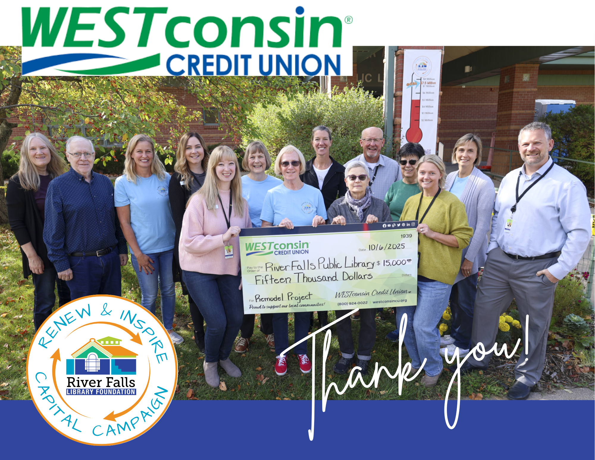 14 people holding a giant check for $15,000 standing in front of a the library building with brick and trees in the background