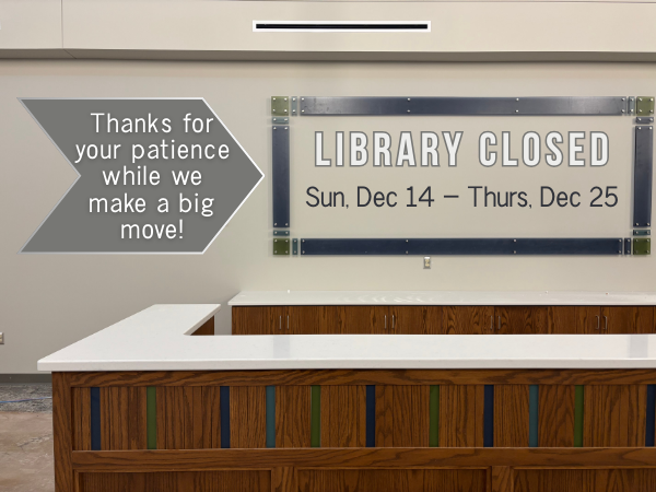 brown wood desk with white countertop and blue and green small stripes beige wall with blue and green rectangle frame and words that read thanks for your patience while we make a big move and library closed Sunday, December 14 through Thursday, December 25