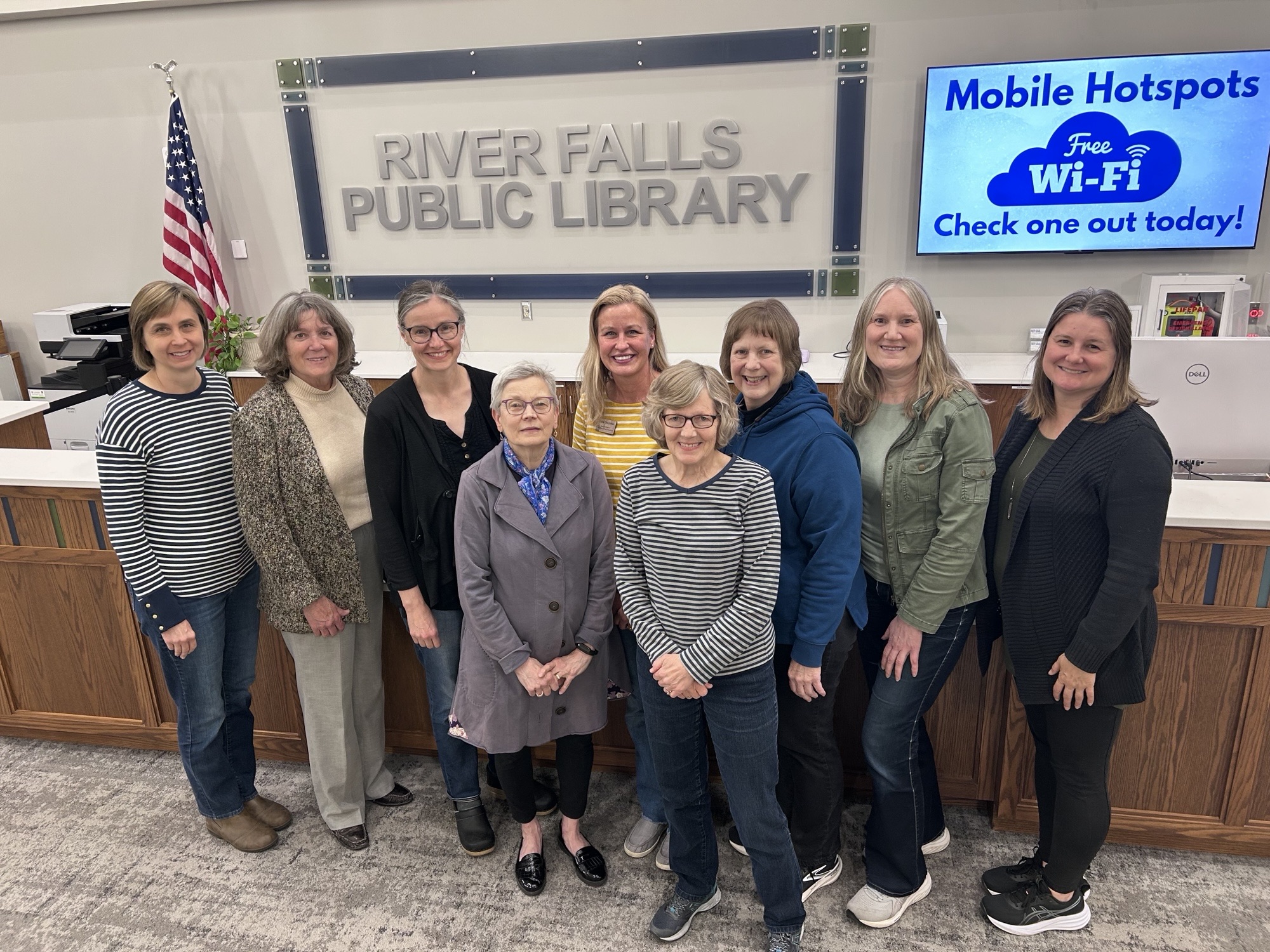 Nine River Falls Library Foundation board members in front of the main level circulation desk